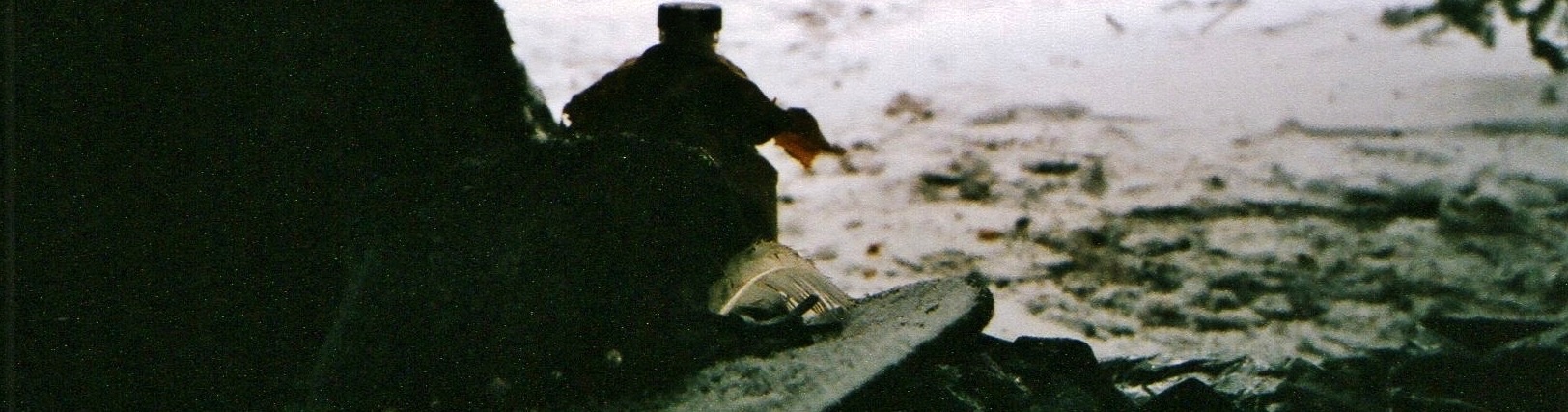 Sonny's cowboy hat and a whiskey bottle on a rock, looking out from the tent at the snow in the Grand Tetons